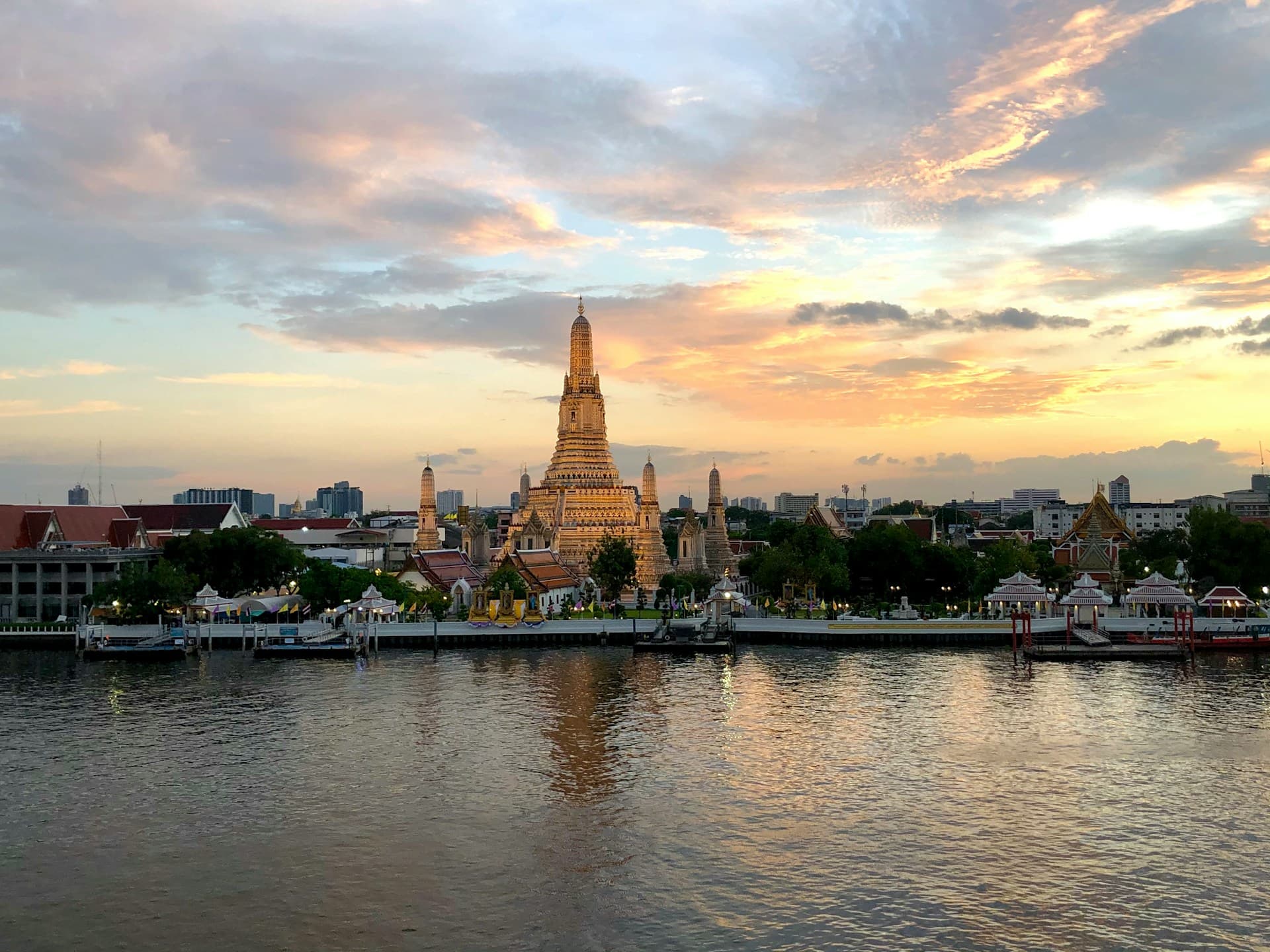 Wat Arun's prang above the Chao Phraya at sunset, seen from across the river
