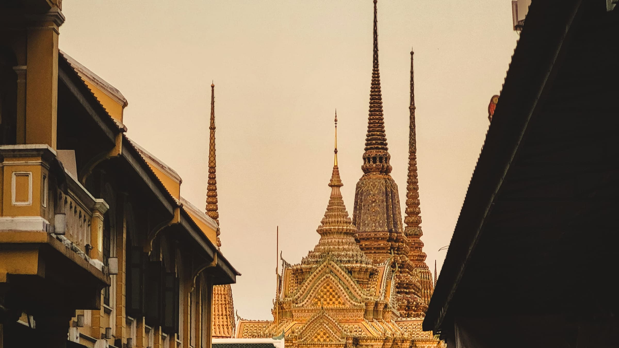 The spires of Wat Pho at the end of a shophouse lane in Rattanakosin